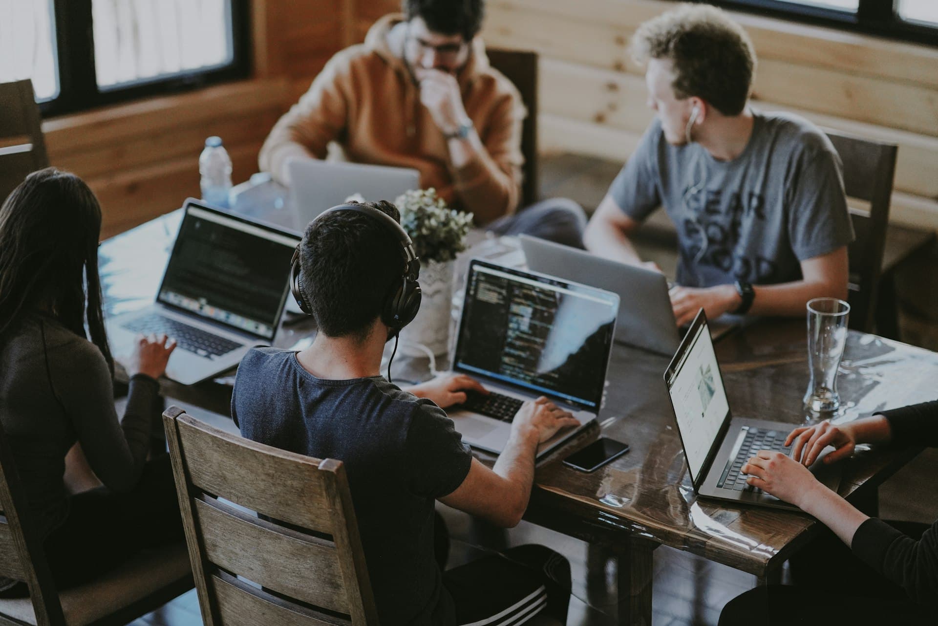 Team of professionals collaborating around a table with laptops